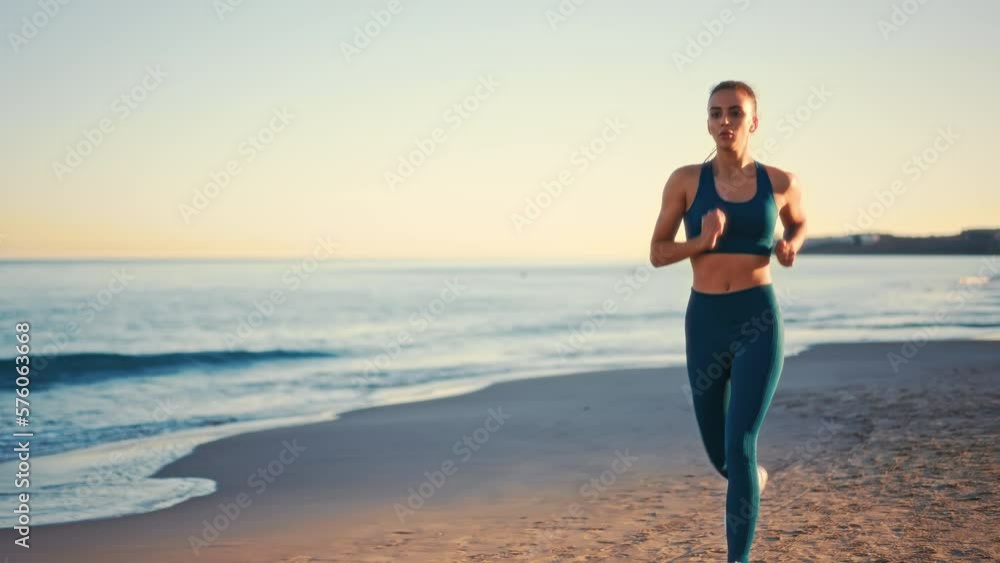 Young pretty fit woman in sportswear running on the beach. Outdoor workout by the sea. Sports and recreation, fitness and healthy lifestyle. Young pretty fit woman in sportswear running on the beach. Outdoor workout by the sea. Sports and recreation, fitness and healthy lifestyle.