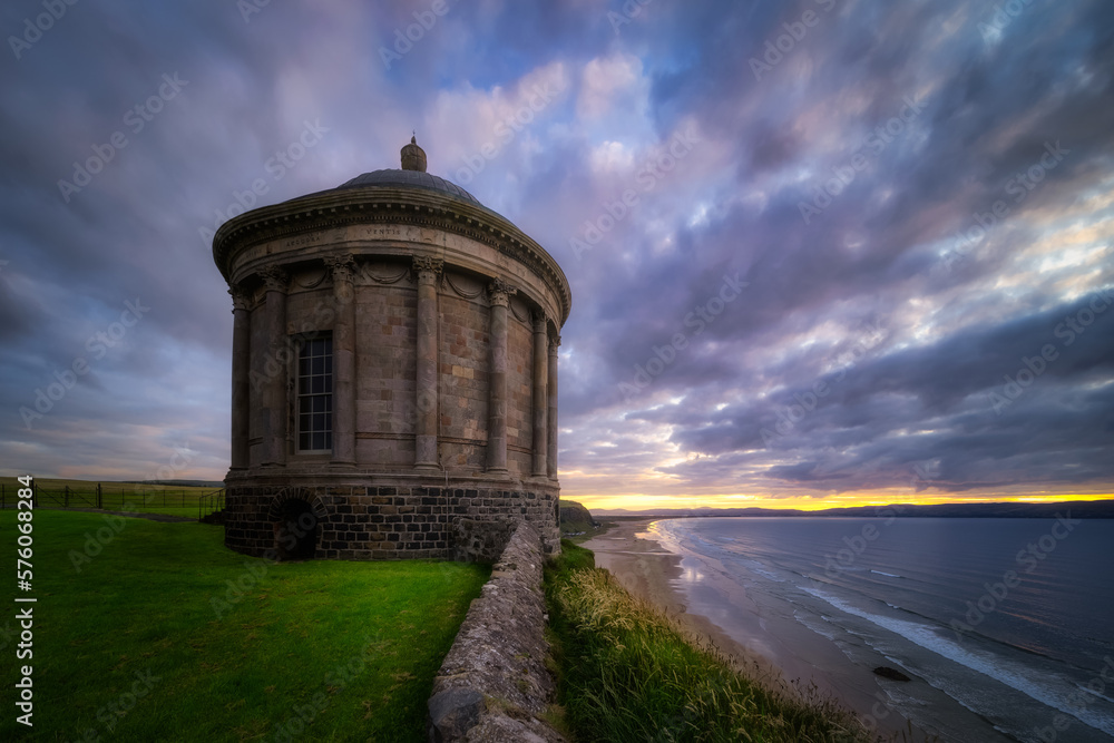 Small Mussenden Temple on the edge of a cliff with dramatic, moody sunset, Castlerock, County Antrim, Northern Ireland