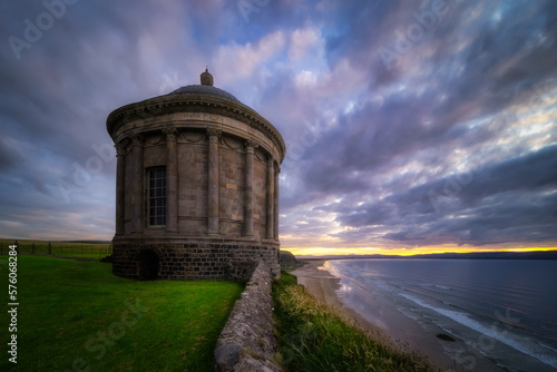 Small Mussenden Temple on the edge of a cliff with dramatic, moody sunset, Castlerock, County Antrim, Northern Ireland photo