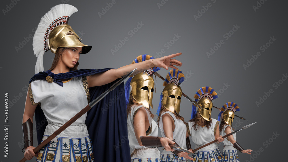 Studio shot of female warlord and three warriors from ancient greece standing in formation.