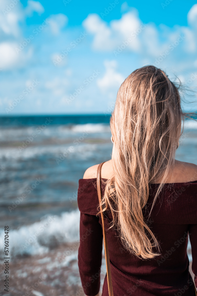 Happy woman on sandy beach smiling. Man on the sea or ocean. Atmospheric photo from a trip or vacation. Nice day. Walk along the coast. Loneliness and connection with nature. Habitat and lifestyle. Happy woman on sandy beach smiling. Man on the sea or ocean. Atmospheric photo from a trip or vacation. Nice day. Walk along the coast. Loneliness and connection with nature. Habitat and lifestyle.