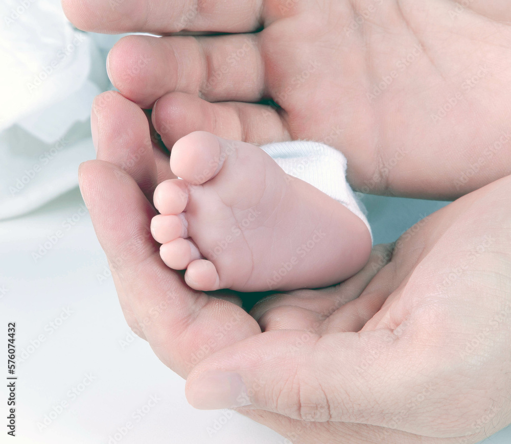 Father holding newborn baby in hands feet Father holding newborn baby in hands feet