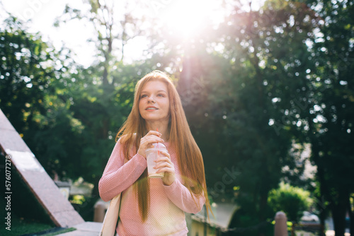 Young woman with cup of iced lemonade in park