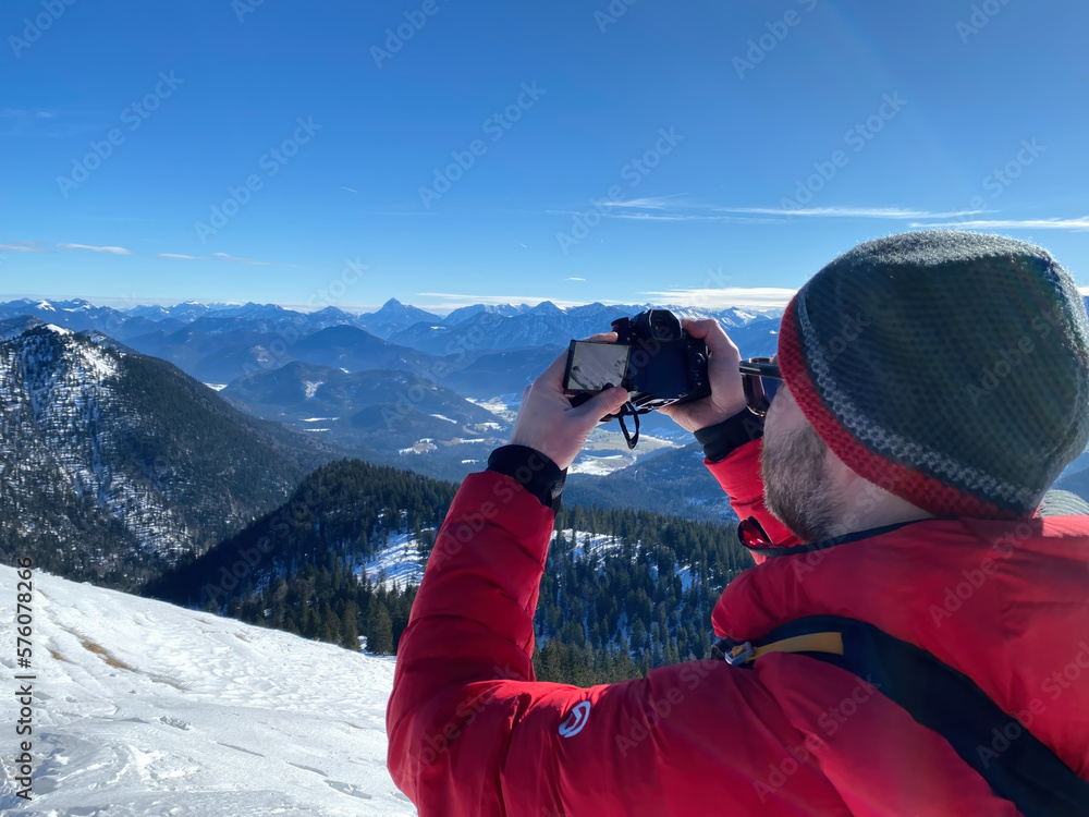 Bavarian Hiker life with camera photo shooting at snow landscape