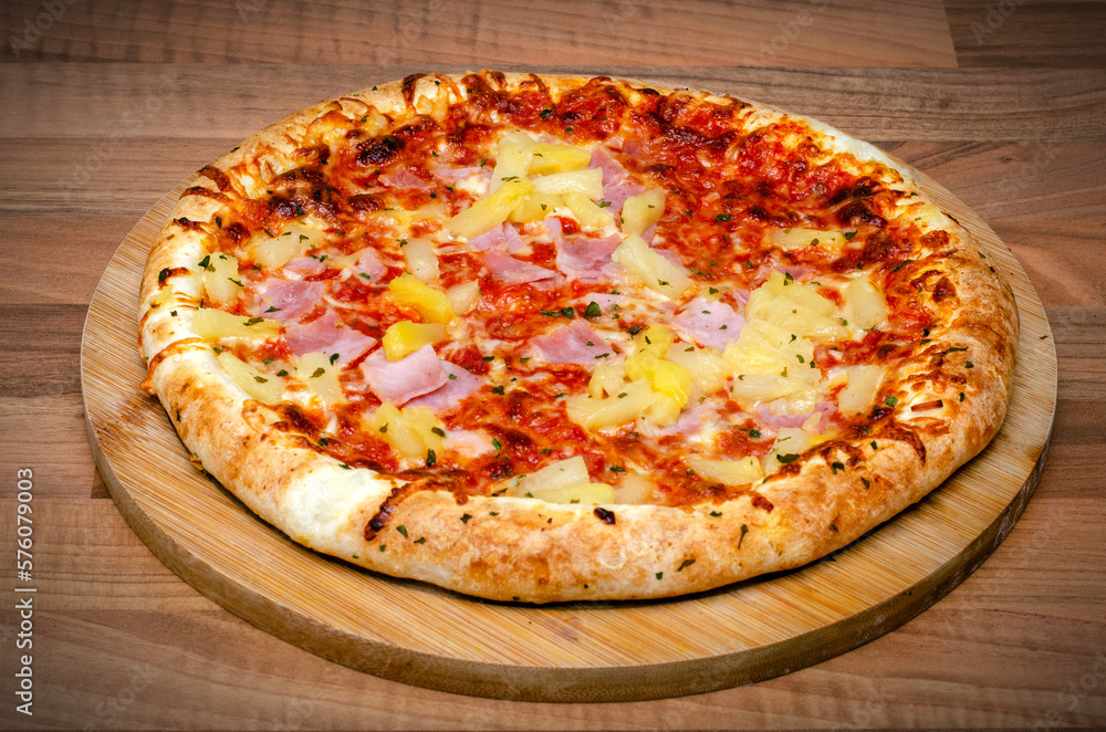 Pizza with sausage and pineapple on wooden background