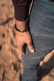Human hand on the sandy beach. Man on the sea or ocean. Atmospheric photo from a trip or vacation. Nice day. Walk along the coast.