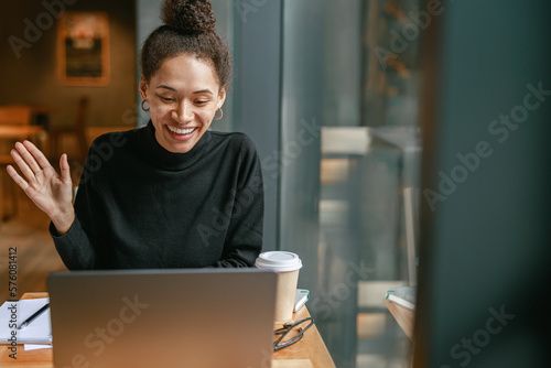 Tableau sur toile Smiling woman freelance talking with client via video call and discuss project s