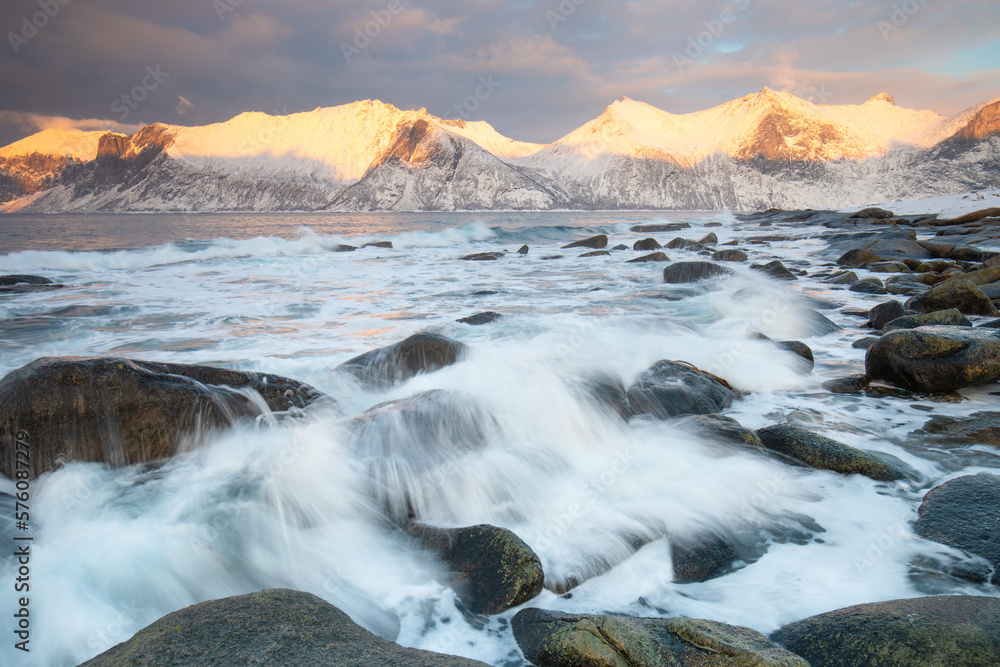 Snow covered mountain range on coastline in winter, Norway. Senja panoramic aerial view landscape nordic snow cold winter norway ocean cloudy sky snowy mountains. Troms county, Fjordgard 