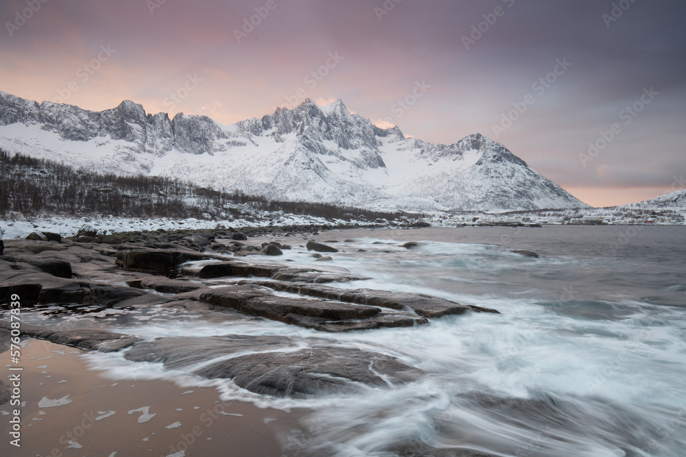 Snow covered mountain range on coastline in winter, Norway. Senja panoramic aerial view landscape nordic snow cold winter norway ocean cloudy sky snowy mountains. Troms county, Fjordgard 