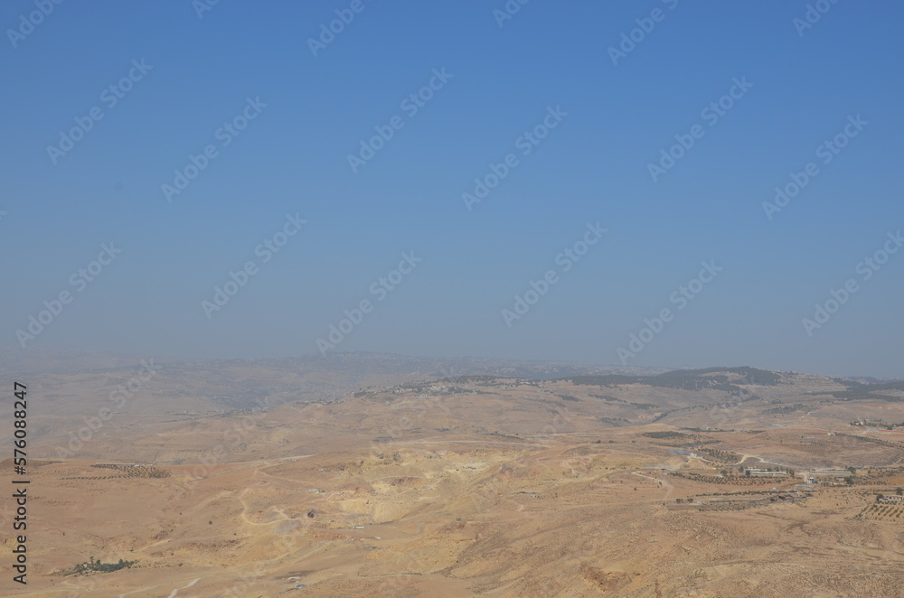 Landscapes of a road crossing the dry desert of Jordan under a bright sunny day Landscapes of a road crossing the dry desert of Jordan under a bright sunny day