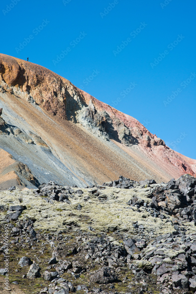 Colorful mountain with a person on top