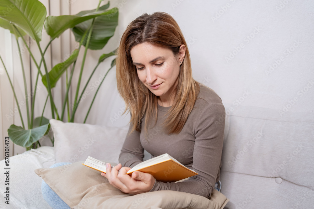 cheerful reader girl enjoying novel story on couch, enjoying bookworms hobby, home leisure time. cheerful reader girl enjoying novel story on couch, enjoying bookworms hobby, home leisure time.