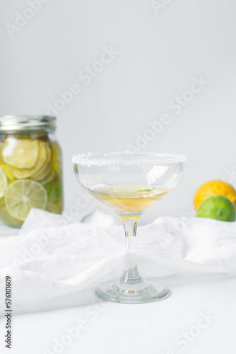 Lime cocktail in a coupe glass, citrus cocktail on  a white table