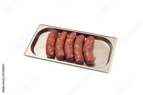 Five raw sausages for barbecue grill on metal tray. Natural meat processed foods. Frankfurters. White background. Selective focus, copy space