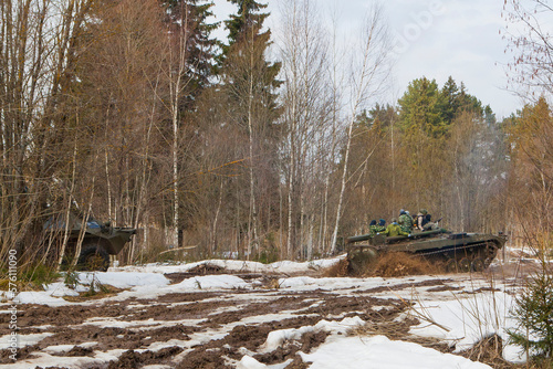 russian military tank with soldiers in ukraine in winter goes on the attack under fire