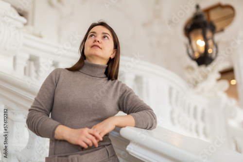 Photography Interested female tourist admiring sumptuous interiors of antique palace while s