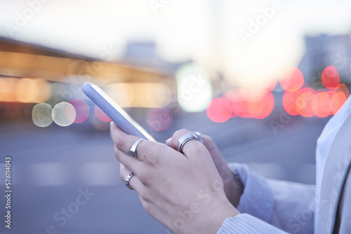 close-up of a woman's hands using her mobile phone in the city