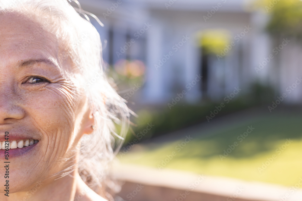 Portrait of happy senior asian woman looking at camera and smiling in garden, with copy space Portrait of happy senior asian woman looking at camera and smiling in garden, with copy space