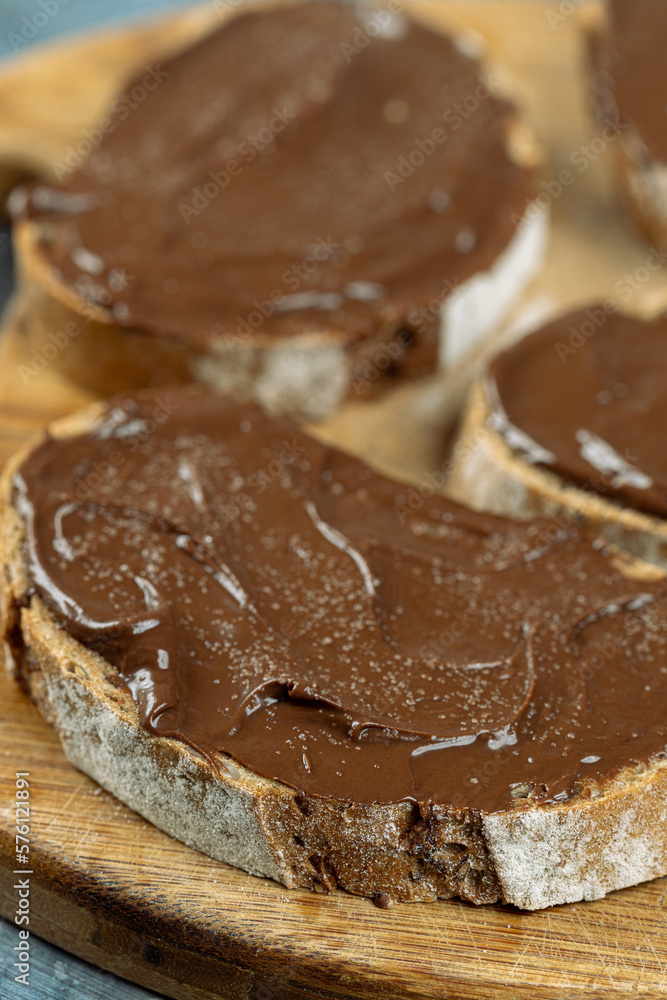 Chocolate cream on the sliced bread above blue background Chocolate cream on the sliced bread above blue background