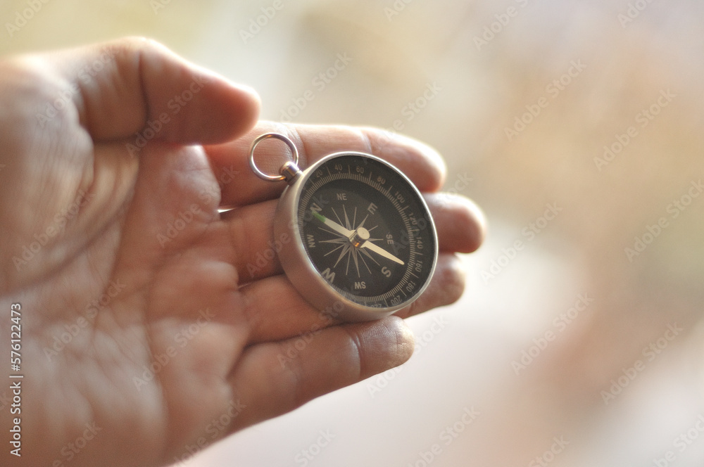Compass in hand blur background Compass in hand blur background