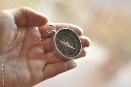 Compass in hand blur background