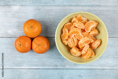Tangerines in the bowl above dark blue food backgrounds