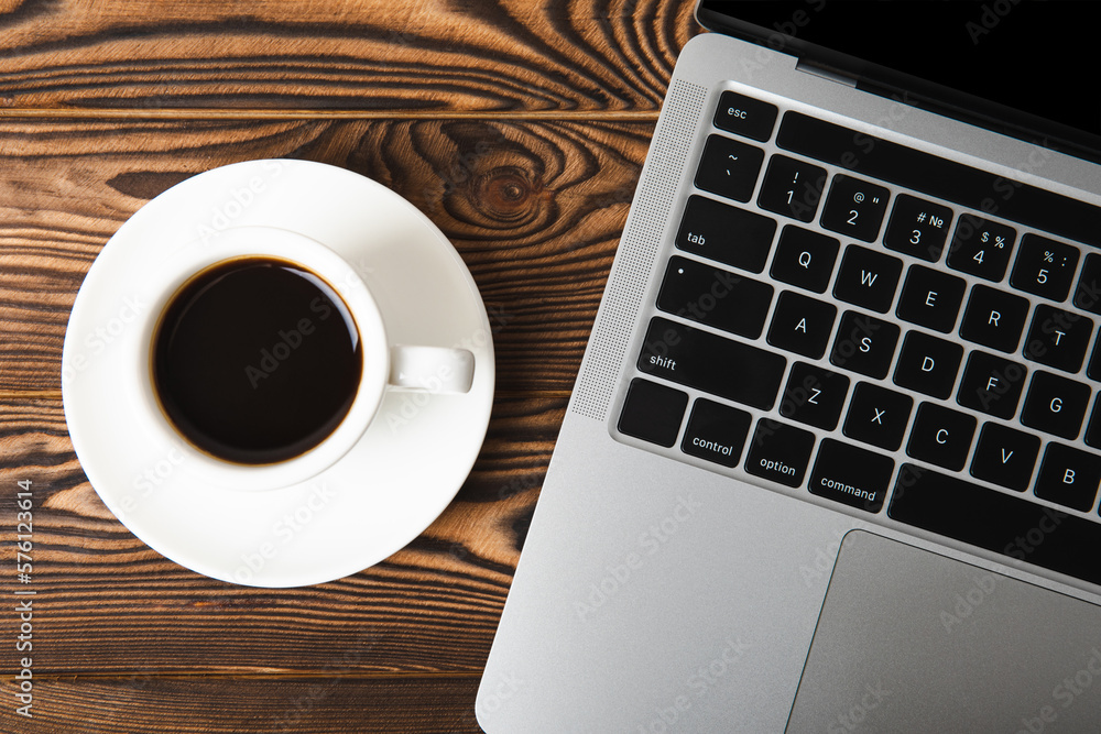 A laptop with a cup of strong aroma coffee on a working office desk. Workspace with copy space. Mocap. Business concept. Place for text. Flat lay A laptop with a cup of strong aroma coffee on a working office desk. Workspace with copy space. Mocap. Business concept. Place for text. Flat lay