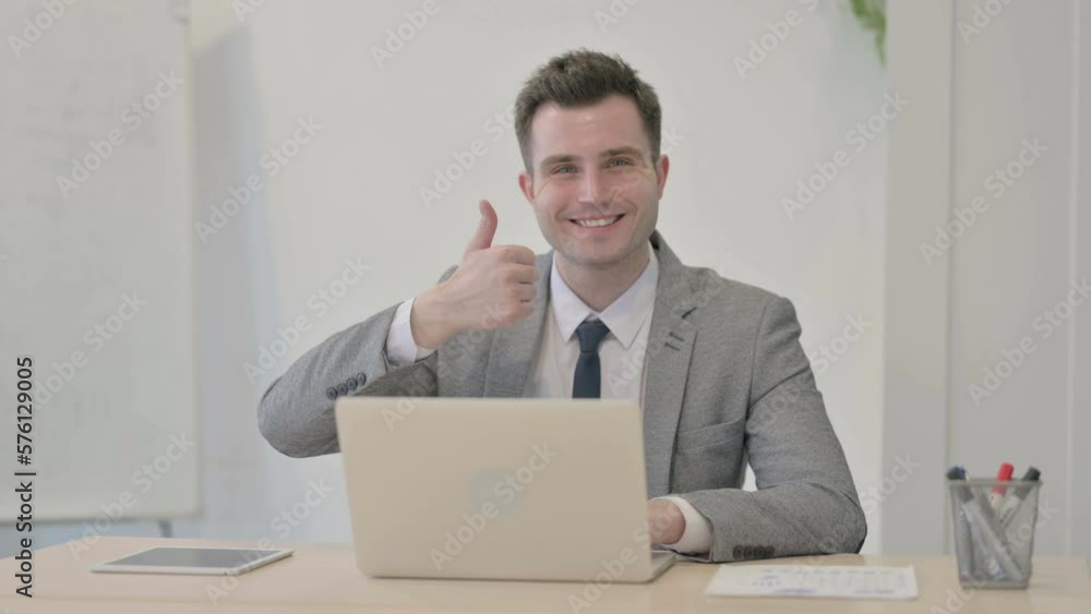 Thumbs Up by Young Businessman Working on Laptop Thumbs Up by Young Businessman Working on Laptop