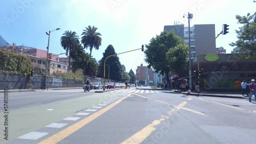 Time lapse in the seventh avenue of Bogota, Colombia in the bike path during the Ciclovia day. Big buildings, cyclists, cars and blue sunny sky photo