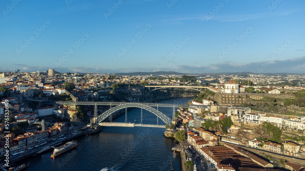 Oporto, Portugal. April 13, 2022: Luis bridge and yellow tram with blue sky.
