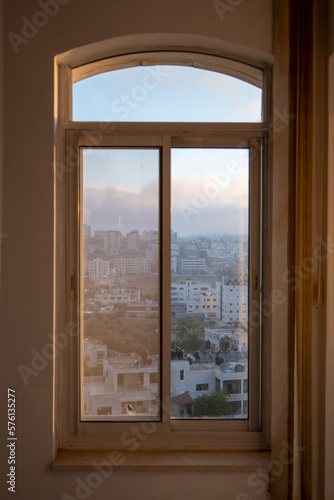 Window with Ramallah Cityscape at Dawn with High Buildings and Trees