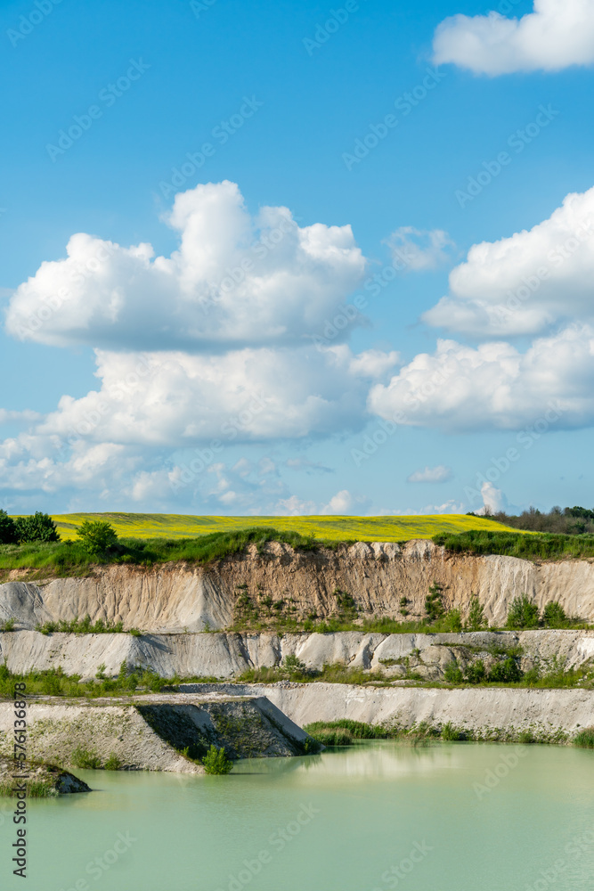 A large sand quarry and a lake. A flooded old abandoned quarry complex. Extraction of sand and stone for industrial applications.
