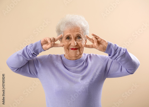 Happy senior woman making p...