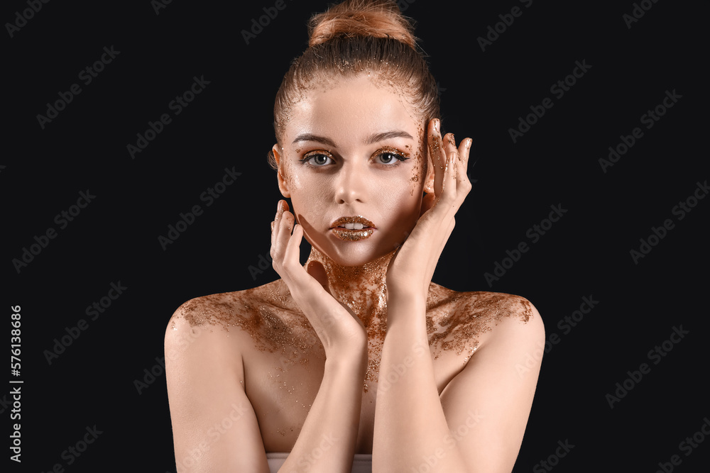 Young woman with golden glitter makeup on black background