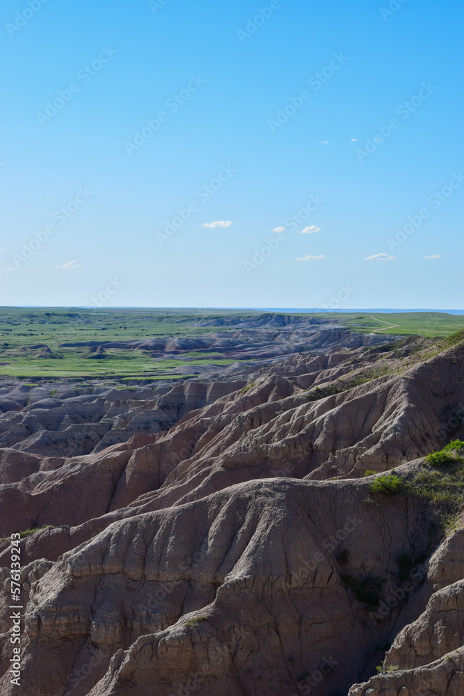 panorama of the mountains exposed rock with blue sky and green grass plateaus badlands