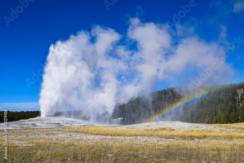 old faithful geyser eruption with rainbow at yellowstone national park in wyoming