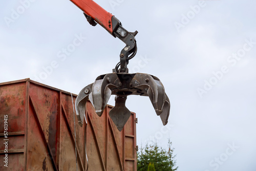 Loading scrap metal into a truck Crane grabber loading metal rusty scrap in the dock A grapple truck loads scrap industrial metal for recycling