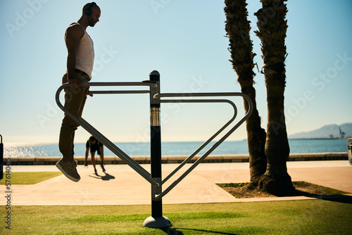 Fotografi young guy exercising with calisthenics workout in an outdoor gym