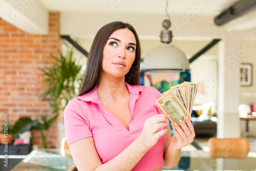 pretty young woman with dollarbanknotes at home interior photo