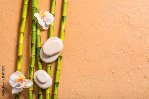 Spa stones  flowers and bamboo on beige background  top view