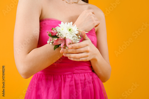 Leinwand Poster Young girl in prom dress and with corsage on yellow background