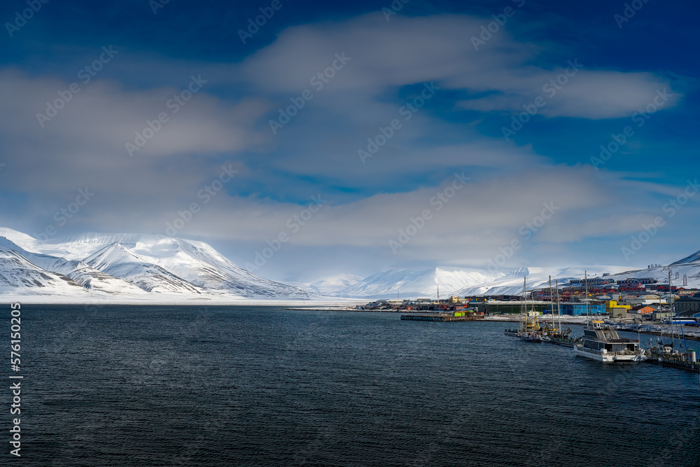 Naklejka premium 2022-05-09 THE SHORELINE WITH BEAUTIFUL SNOW COVERED MOUNTAINS AND SKY NEAR THE TOWN OF LONGYEARBEAN ON SVALBARD NORWAY IN THE ARCTIC