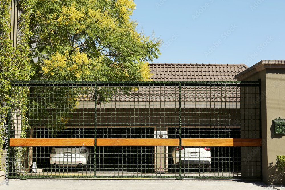 Fototapeta premium Security metal gates near trees and estate outdoors