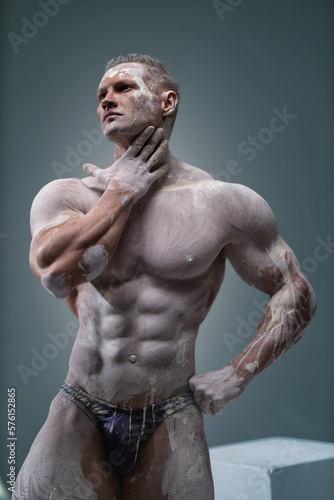 Muscular man touching himself, male posing in studio