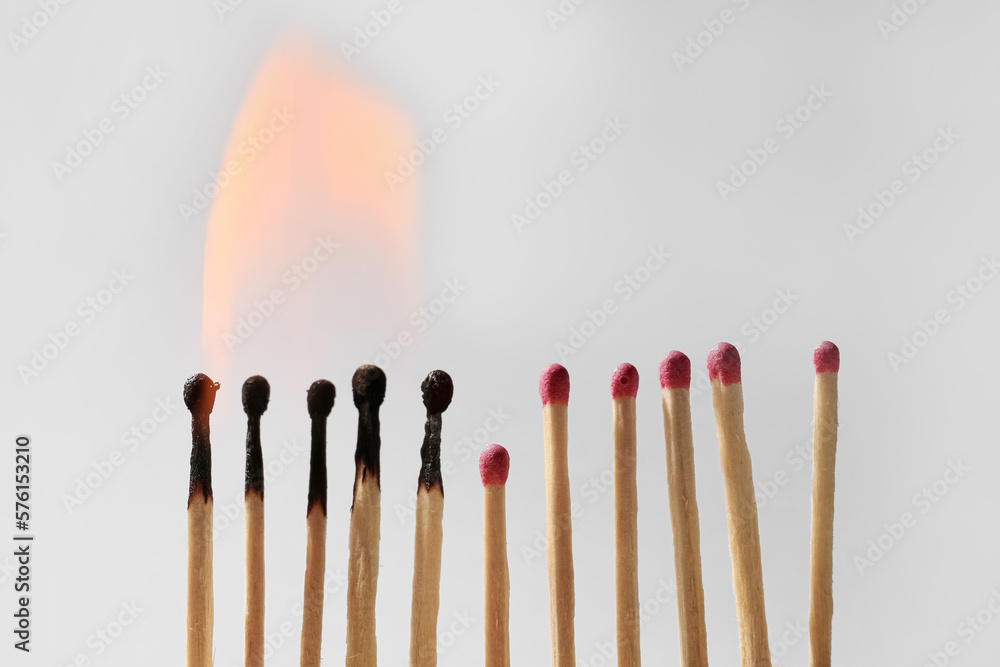 Burning and whole matches on light grey background. Space for text Burning and whole matches on light grey background. Space for text
