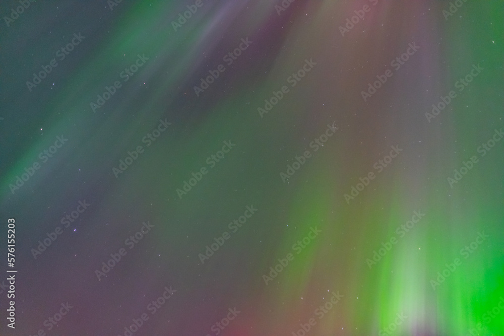 Beautiful bright curtains of Aurora Borealis Northern Lights seen in Yukon Territory with green, purple and pink tones. 