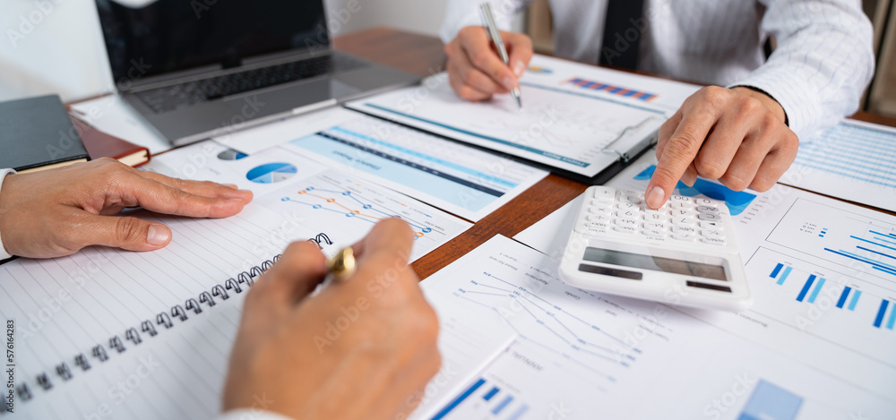 Asian businessmen discuss graphs and chart data analysis and use calculators to calculate numbers. business finance and accounting concepts. Asian businessmen discuss graphs and chart data analysis and use calculators to calculate numbers. business finance and accounting concepts.