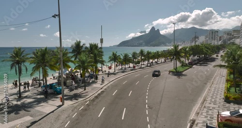 Aerial above main street and palm trees by Ipanema Beach in Rio de Janeiro. People relaxing on the famous beach photo