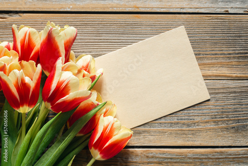 Stylish greeting card. Fresh tulips on wooden background, flat lay. Floral Greeting card template with space for text. Happy women's day. Happy Mother's day, copy space.