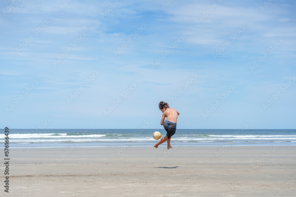 garoto controlando a bola de futebol na praia vazia garoto controlando a bola de futebol na praia vazia